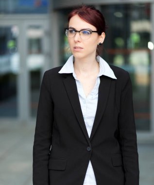 Modern bir şehir ortamında kendine güvenen genç bir bayan yönetici.