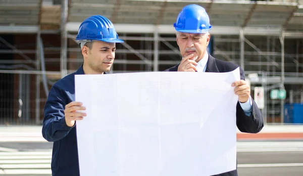 Nşaat Alanındaki Bina Planlarını Inceleyen Iki Mimar — Stok fotoğraf