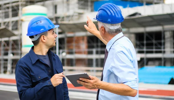 建築現場で建築計画を検討する2人の建築家 — ストック写真