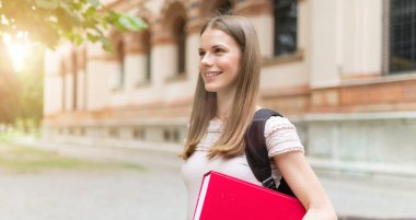 Üniversite önünde gülümseyen bir öğrencinin portresi