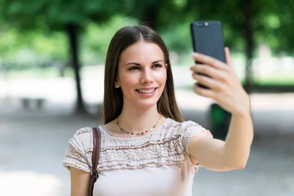 Genç Bir Kadın Cep Telefonunu Selfie Çekmek Için Kullanıyor — Stok fotoğraf