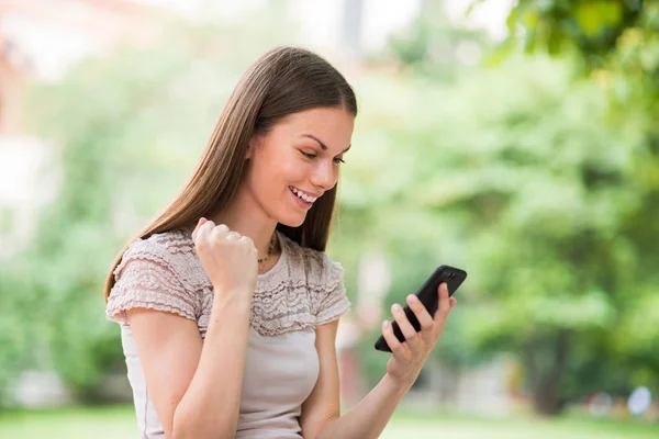 Lycklig Kvinna Som Tittar Sin Mobiltelefon — Stockfoto