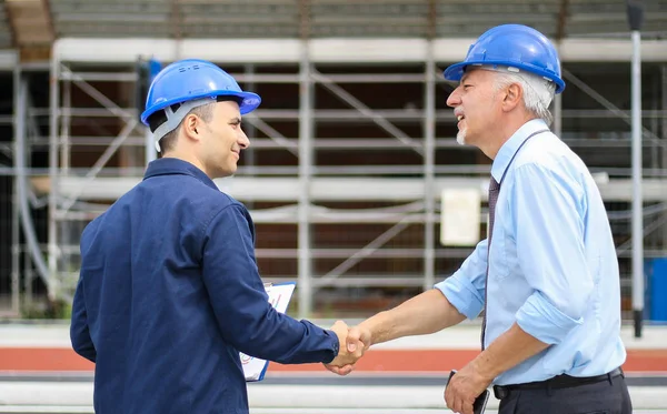 Két Mérnök Kézfogást Egy Építkezésen — Stock Fotó