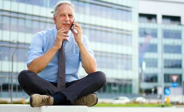Starszy Biznesmen Rozmawia Telefon Siedzi Ławce Zewnątrz Mieście — Zdjęcie stockowe