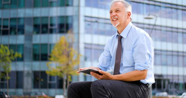 Senior Manager Met Behulp Van Zijn Digitale Tablet Buiten Zittend — Stockfoto