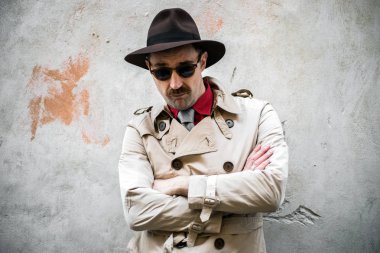 Gettoda kollarını kavuşturmuş bir dedektifin portresi.