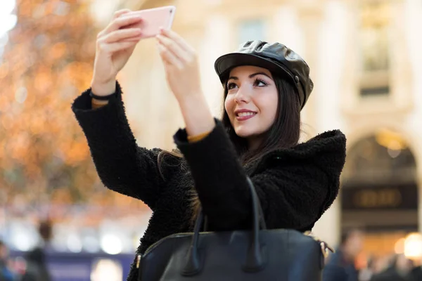 年轻女子拿着智能手机在户外拍照 — 图库照片