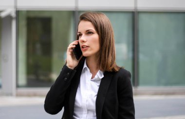 Telefonda konuşan genç bir kadının portresi.