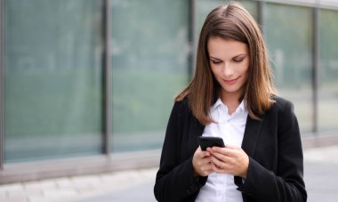 Açık bir smartphone kullanarak gülümseyen iş kadını