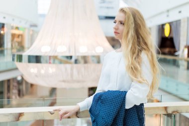 Düşünceli bir iş kadını. Düşünceli bir ifadeyle, parlak bir alışveriş merkezinde.