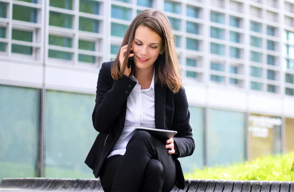 Dışarıda Dijital Tablet Kullanan Gülümseyen Kadını Bankta Oturuyor Telefonda Konuşuyor — Stok fotoğraf
