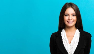 Mavi arka planda gülümseyen bir iş kadını