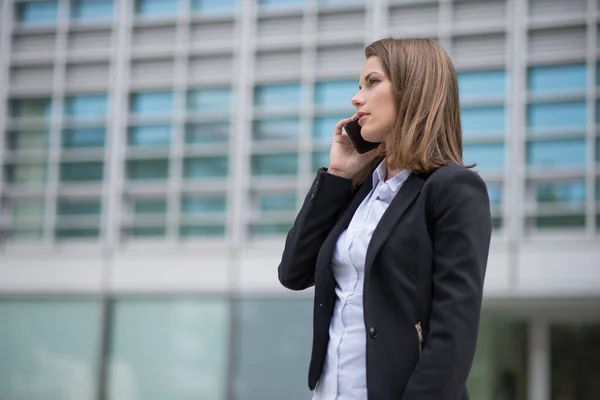 年轻的女商人在讲她的手机 — 图库照片