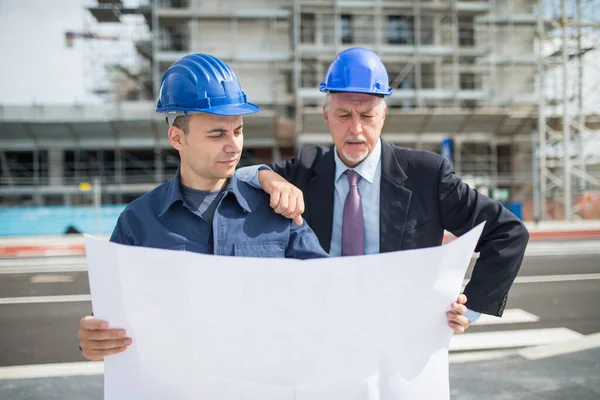 建筑师解释在建筑工地前对工地经理做什么工作 — 图库照片