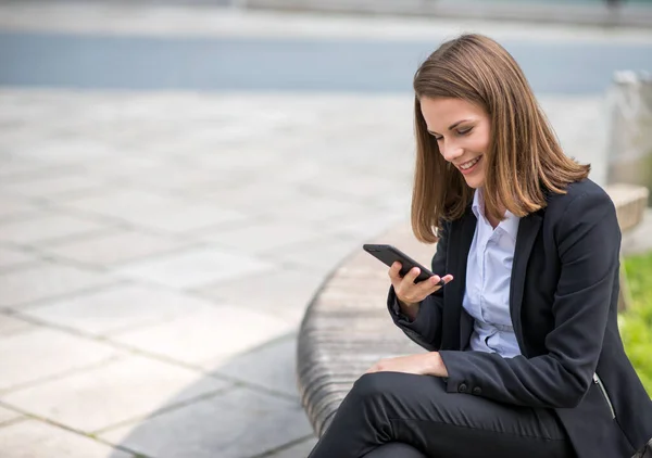 Usmívající Mladá Podnikatelka Pomocí Svého Mobilního Telefonu — Stock fotografie
