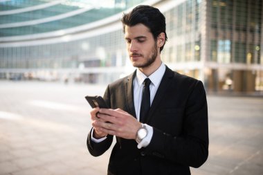 İş adamı iş ortamında akıllı telefonunda uygulama kullanıyor.