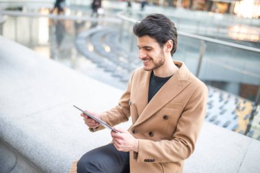 Genç adam tabletini şehir dışında kullanıyor.
