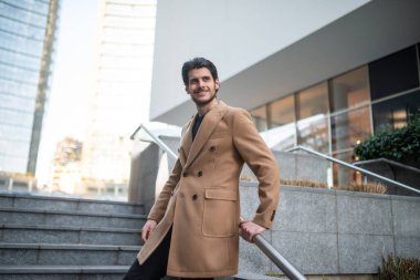 Gülümseyen genç bir adamın açık hava moda portresi.