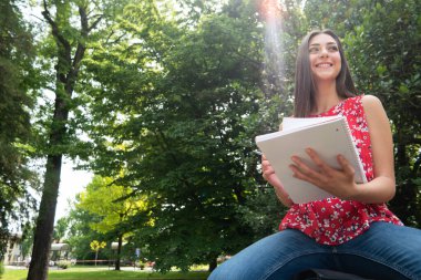 açık havada otururken okuyan kadın