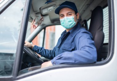 Maskeli minibüs ya da kamyon şoförü yolda.