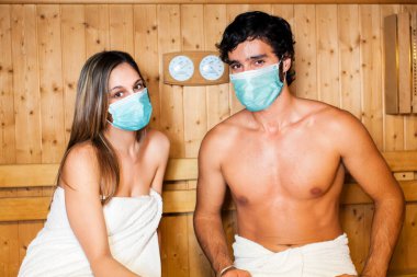 Güzel bir çift, saunaya maske takarak rahatlıyor, Coronavirus konsepti