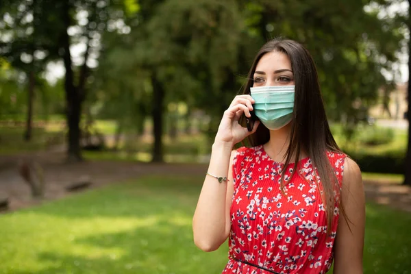 Mujer Joven Enmascarada Hablando Por Teléfono —  Fotos de Stock