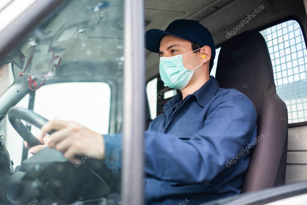 Masked truck driver giving driving a van during coronavirus pandemic