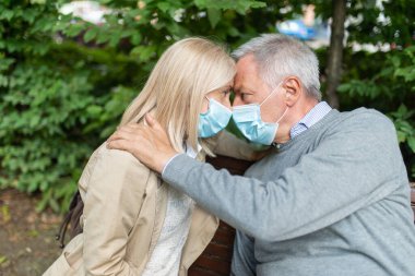Coronavirus salgını sırasında parkta romantik olgun bir çift. Aşk ve umut kavramı.