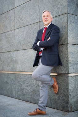 Bir şehrin duvarında kıdemli bir işadamı yatıyor.