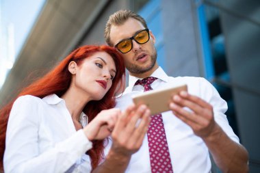 Açık havada cep telefonu kullanan iş adamları.