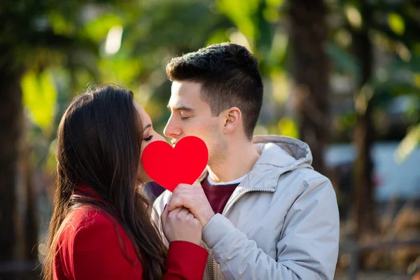 Casal Jovem Cobrindo Seu Beijo Com Coração — Fotografia de Stock