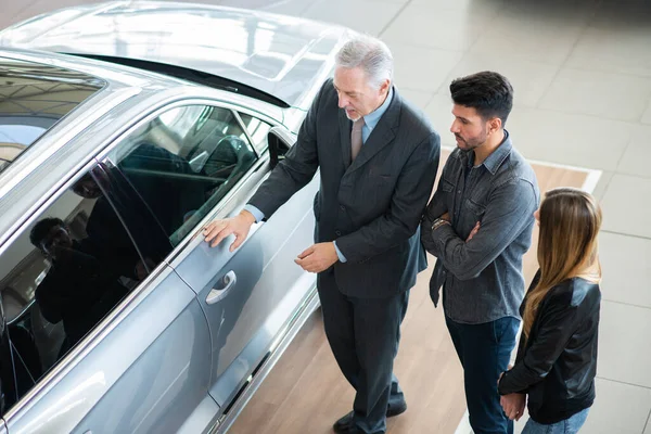 Feliz Joven Familia Hablando Con Vendedor Elección Nuevo Coche Una —  Fotos de Stock