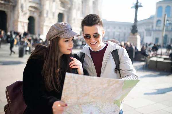 イタリアのミラノで地図を持っている若い観光客のカップル — ストック写真