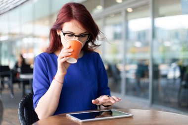Caddedeki bir kahve dükkanının terasında düşünmekten mutlu bir kadın.