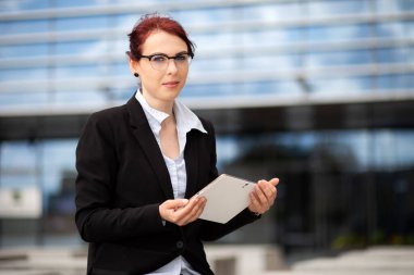Gülümseyen iş kadını dijital tablet kullanıyor.