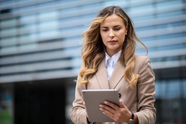 Sarışın genç iş kadını dijital tablet kullanıyor.