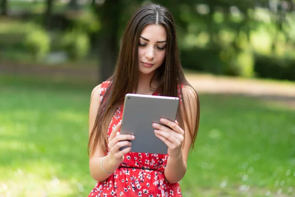 Parkta Dijital Tablet Kullanan Genç Bir Kadın — Stok fotoğraf