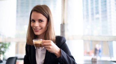 İş kadını espresso içiyor.