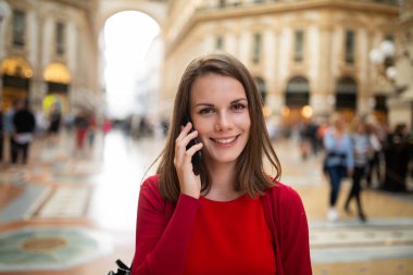 Avrupa 'da yürürken telefonla konuşan genç bir kadın.