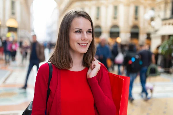 ミラノの赤いショッピングで身に着けている笑顔の若い女性 イタリア — ストック写真