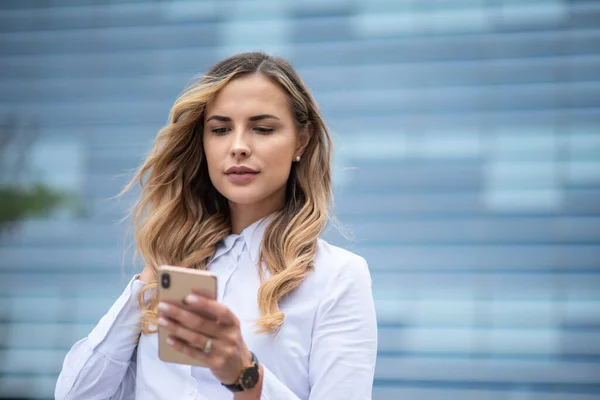 Affärskvinna Som Använder Sin Mobiltelefon Framför Kontorsbyggnaden — Stockfoto