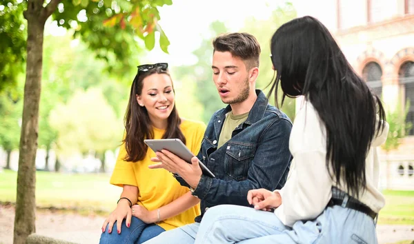 Tre Studenti Che Studiano Insieme Tablet Digitale Seduti Una Panchina — Foto Stock