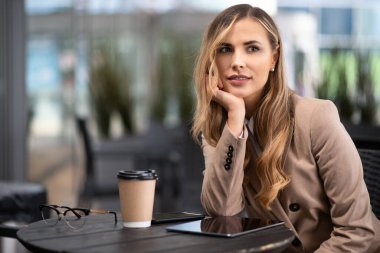 Genç sarışın iş kadını kahve içiyor.