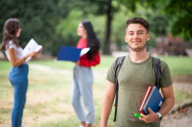 Okulun, üniversitenin ya da üniversitenin yakınındaki bir grup arkadaşın önünde genç bir öğrenci