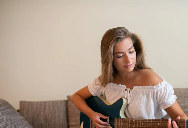 Mujer Joven Tocando Guitarra Eléctrica Sofá Apartamento —  Fotos de Stock