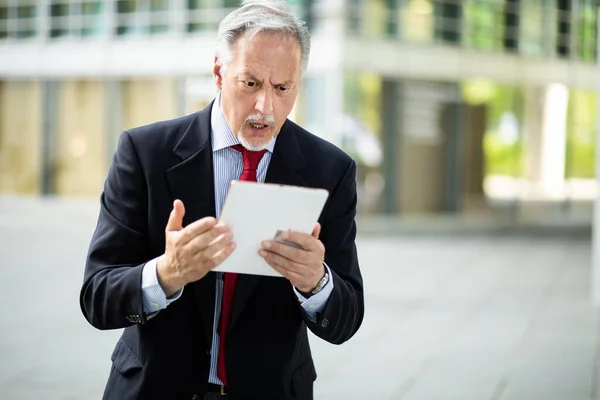 Starší Manažer Vypadá Naštvaně Protože Čte Špatné Zprávy Svém Tabletu — Stock fotografie
