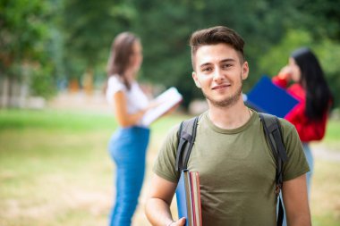 Okulun, üniversitenin ya da üniversitenin yakınındaki bir grup arkadaşın önünde genç bir öğrenci