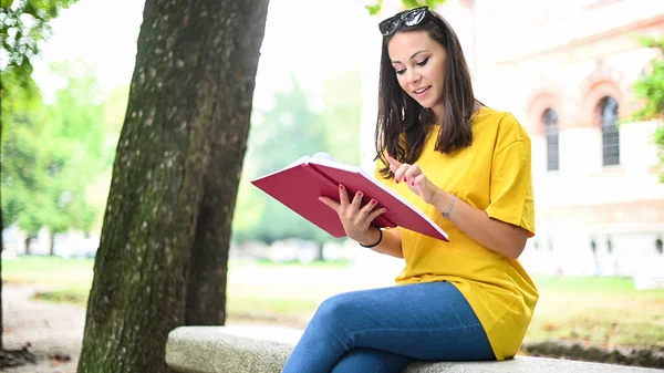 Güzel Bir Üniversite Öğrencisi Parkta Bir Bankta Kitap Okuyor — Stok fotoğraf