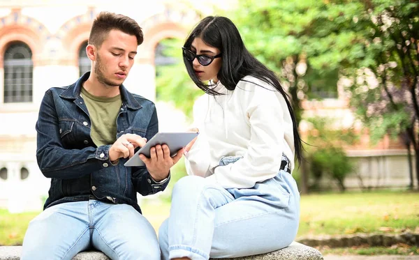 Dwóch Studentów Studiujących Razem Tabletem Cyfrowym Siedzącym Ławce Świeżym Powietrzu — Zdjęcie stockowe
