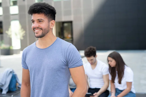 Jonge Glimlachende Man Die Voor Een Groep Mensen Loopt — Stockfoto